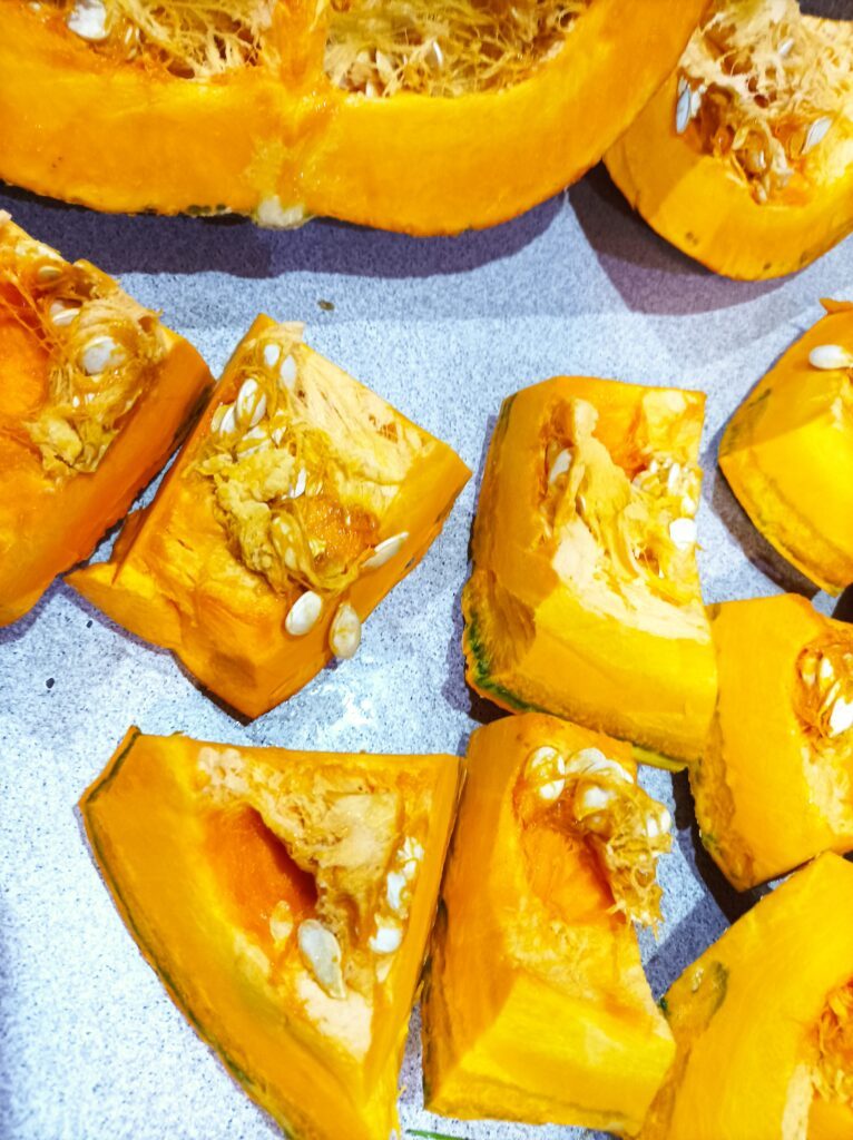 Dynia pokrojona na mniejsze części do zupy z dyni Dynia pokrojona na mniejsze części łatwiej się obiera ze skórki