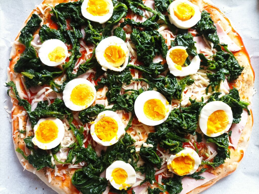 Pizza na grubym cieście oraz szpinak z jajkiem