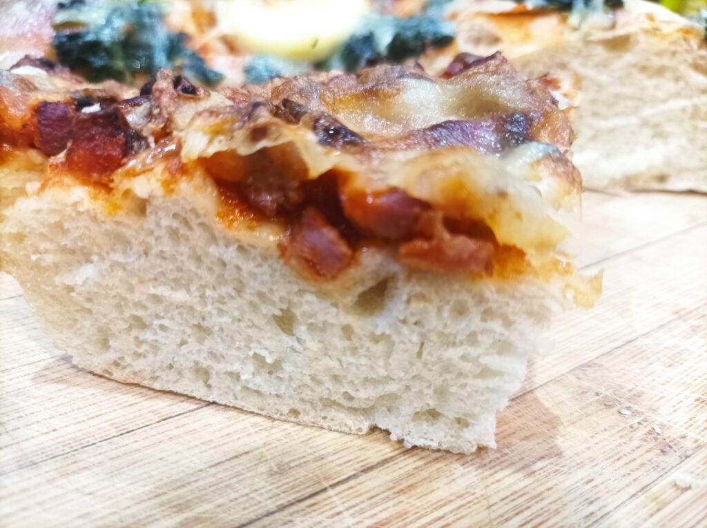 Pizza na grubym cieście z kiełbasą, pieczarkami i cebulą smakuje równie dobrze na zimno